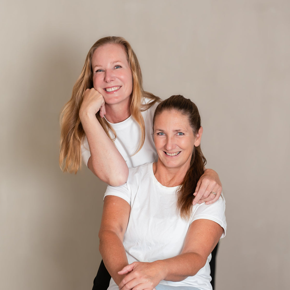 Oprichters Cathy en Angela, een leunt lachend op de schouder van de ander