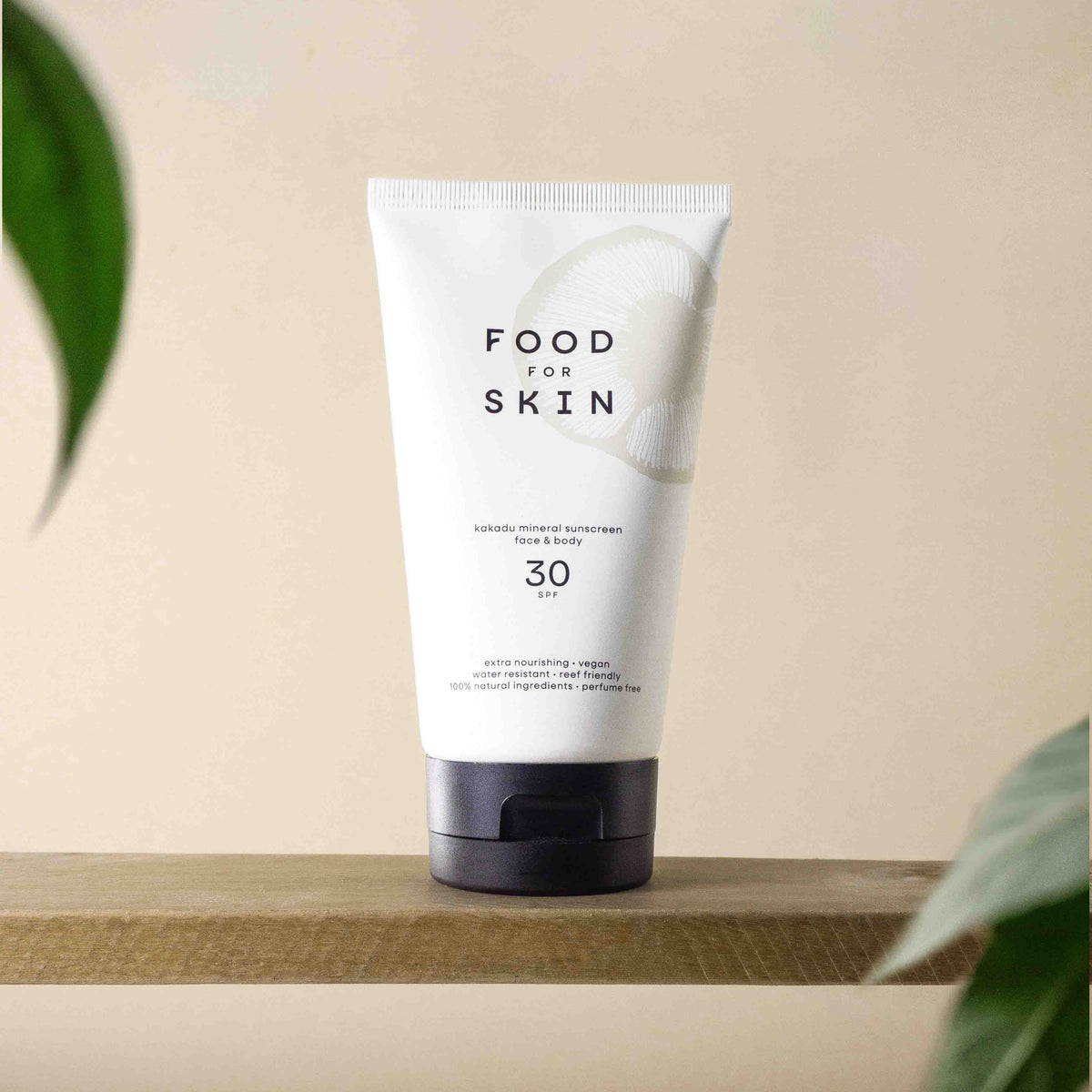 SPF30-tube op plank met plantenschaduw