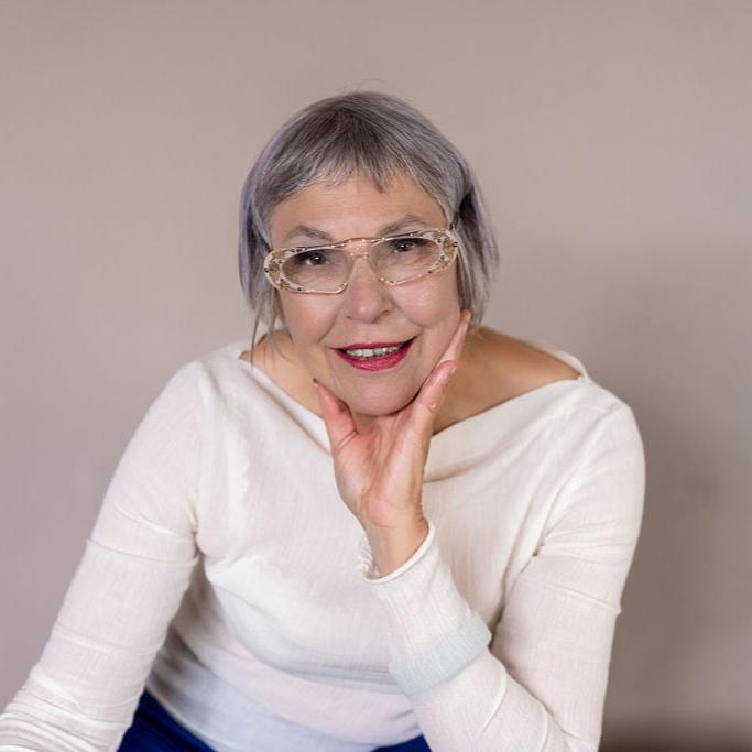 Vrouw met kort grijs haar, handen langs haar gezicht