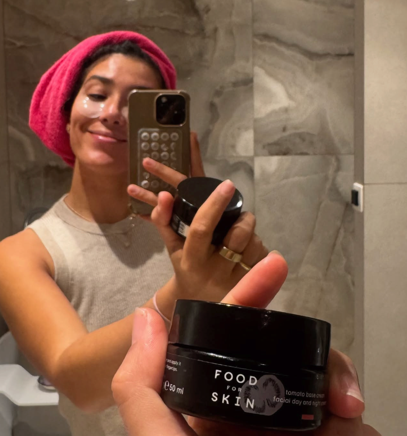 Vrouw maakt een spiegelselfie met een pot crème